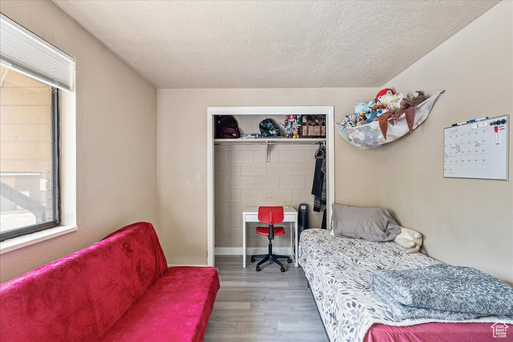 Bedroom featuring wood finished floors, a closet, and a textured ceiling