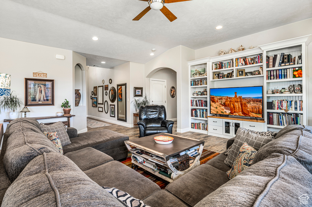 Living room featuring arched walkways, ceiling fan, recessed lighting, a textured ceiling, and wood finished floors