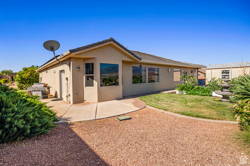 Rear view of property featuring stucco siding and a patio area