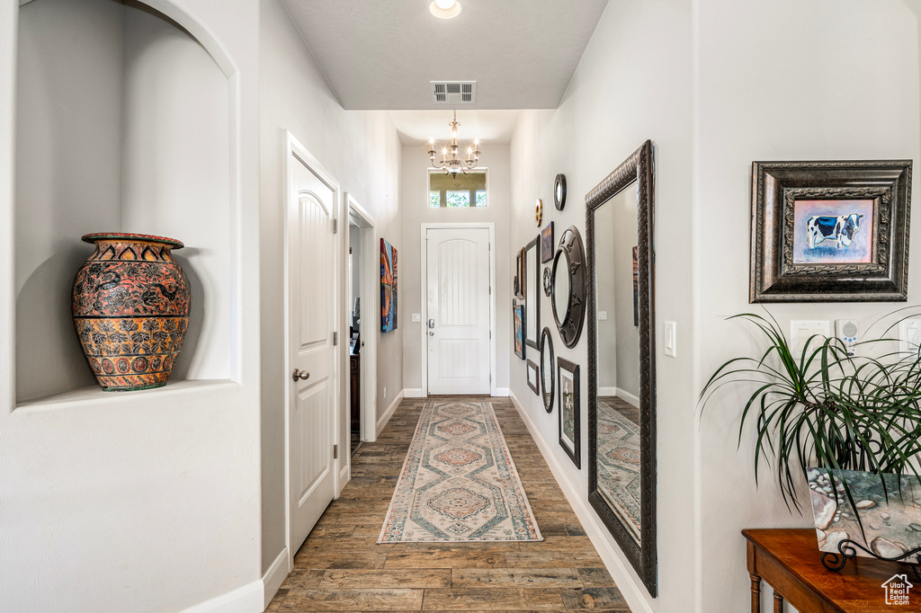 Foyer with a chandelier and wood finished floors