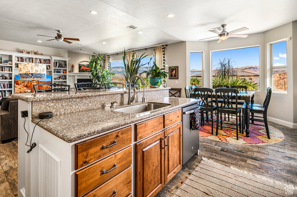 Kitchen with a ceiling fan, dishwasher, a kitchen island with sink, recessed lighting, and dark wood-type flooring