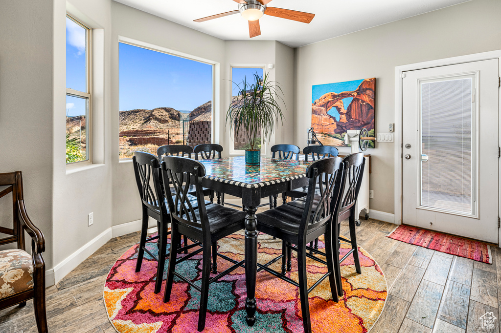 Dining area with a ceiling fan, wood finished floors, and a mountain view