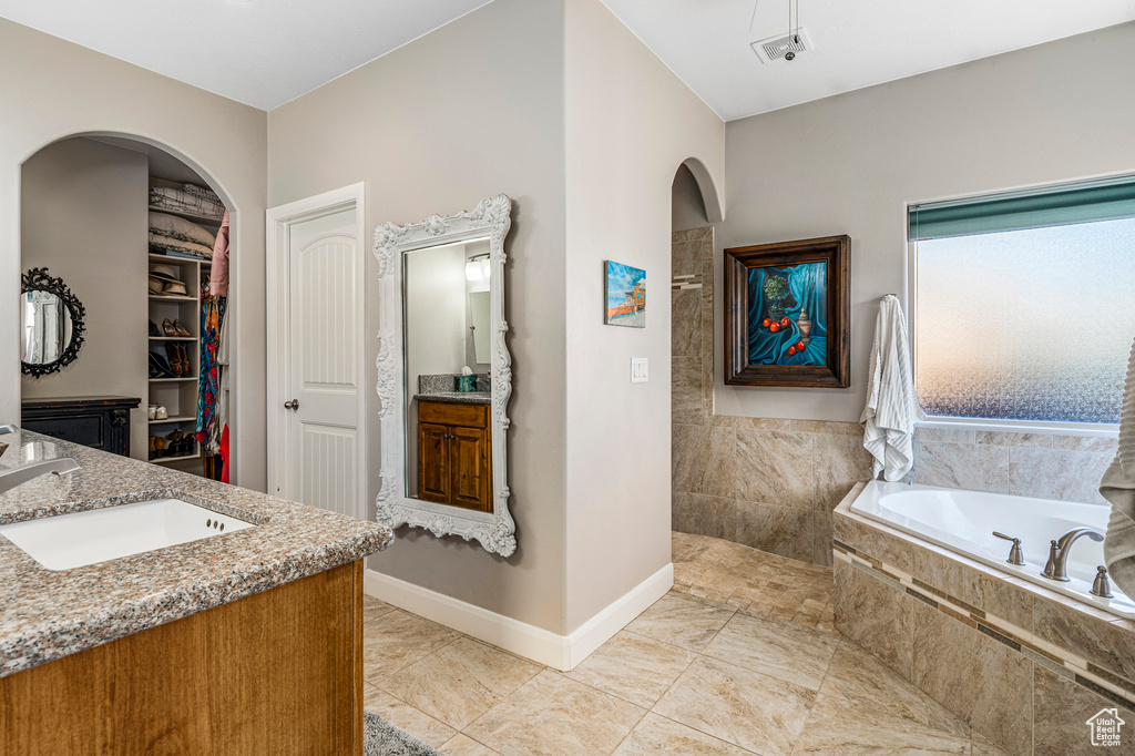 Full bathroom featuring vanity, a garden tub, and a walk in shower