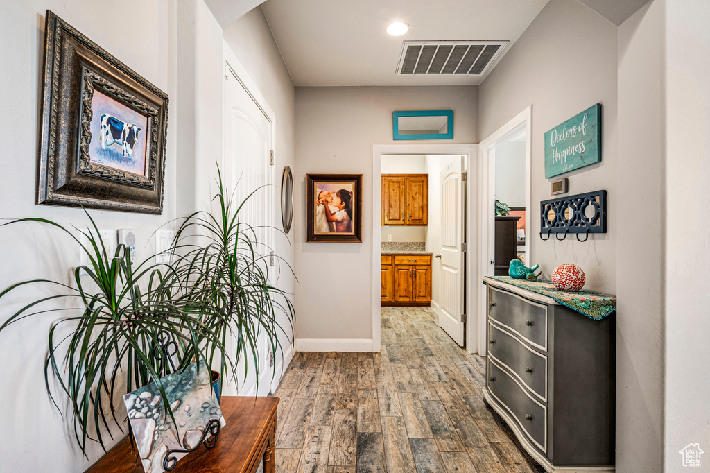 Corridor featuring hardwood / wood-style floors, arched walkways, and recessed lighting