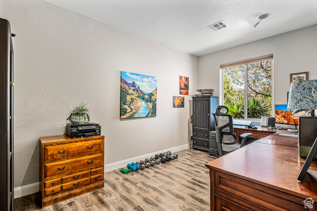 Office area with light wood-type flooring and baseboards