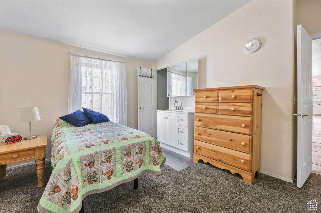 Carpeted bedroom featuring multiple windows and lofted ceiling