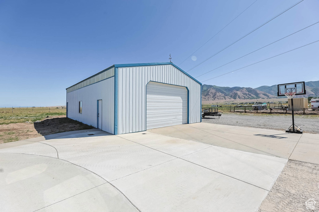 Detached garage with concrete driveway and a mountain view