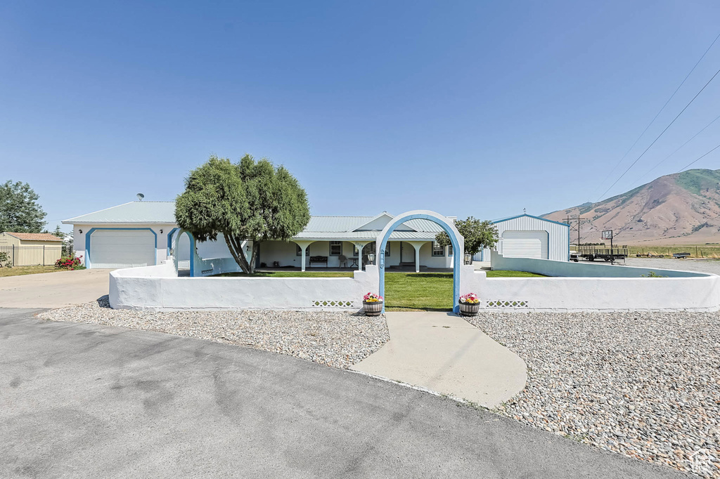View of front of house with a mountain view and driveway