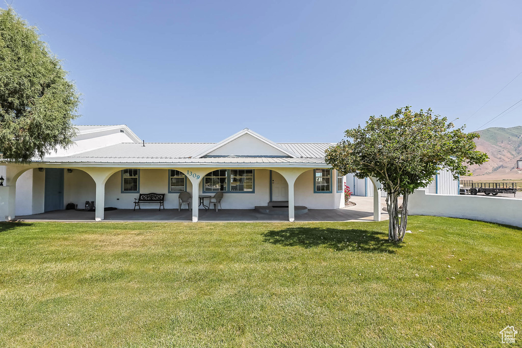 Back of house featuring a yard and stucco siding