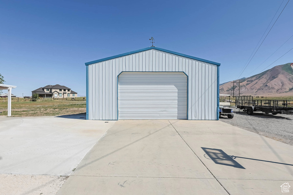 Detached garage with concrete driveway and a mountain view