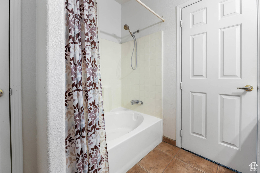 Full bathroom with tile patterned floors and shower / bath combo with shower curtain