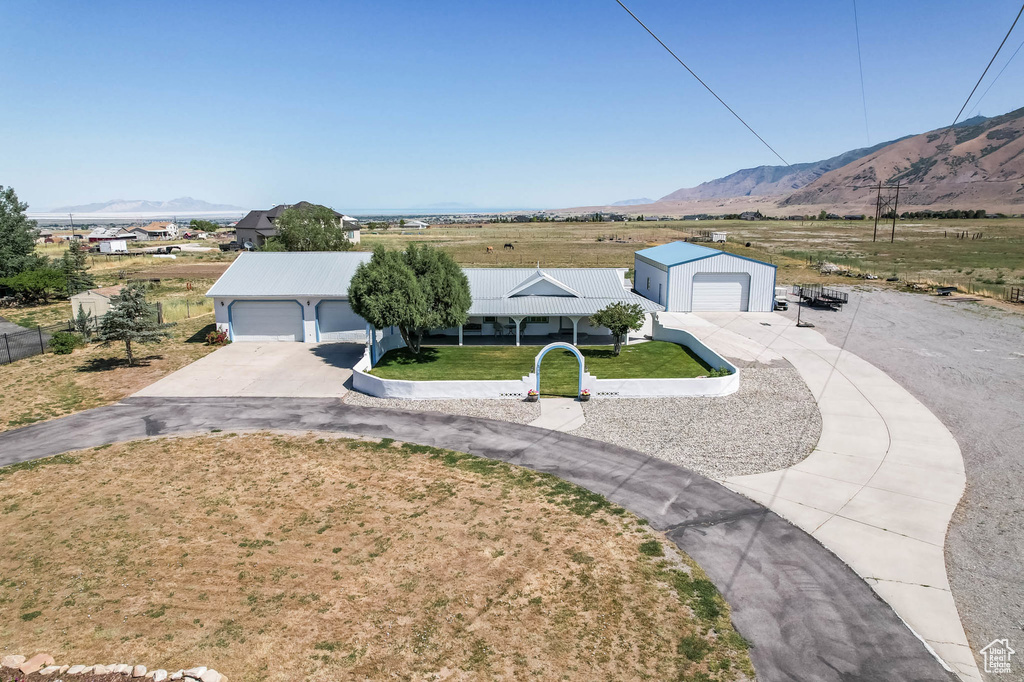 Ranch-style home with a detached garage, a mountain view, and a front yard