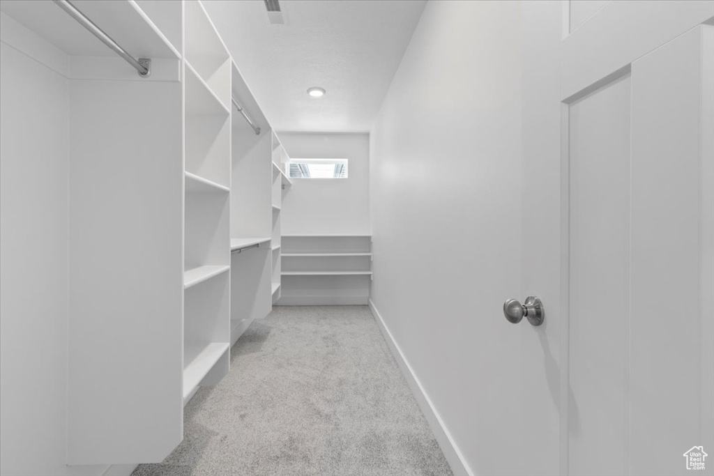 Walk in closet with light carpet