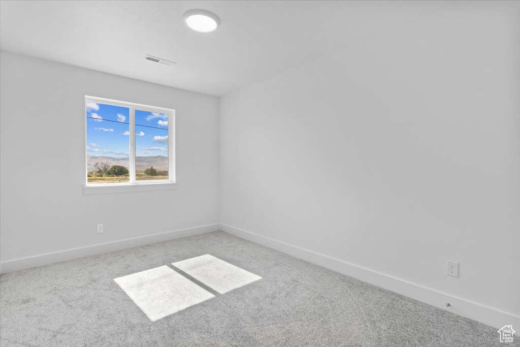Empty room featuring carpet floors and baseboards