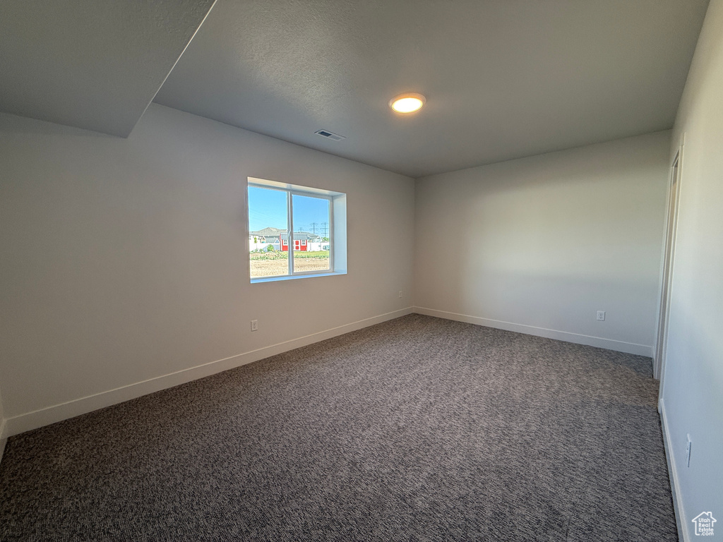 Carpeted empty room with baseboards and recessed lighting