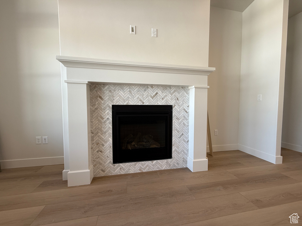 Detailed view of wood finished floors and a tile fireplace