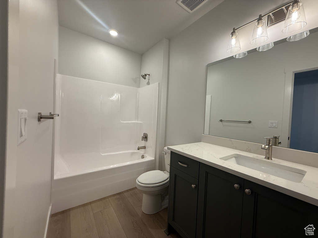 Bathroom with wood finished floors, vanity, and shower / bathtub combination