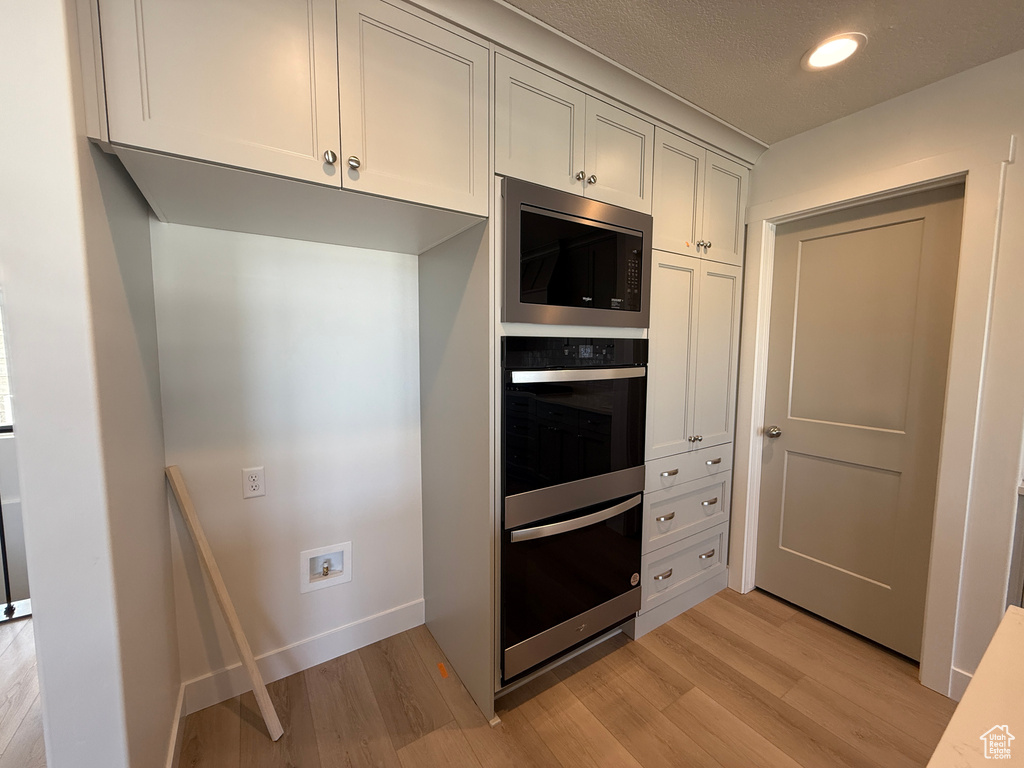Kitchen featuring appliances with stainless steel finishes, light wood-type flooring, recessed lighting, and light countertops