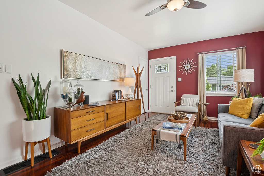 Living room with dark wood finished floors and ceiling fan