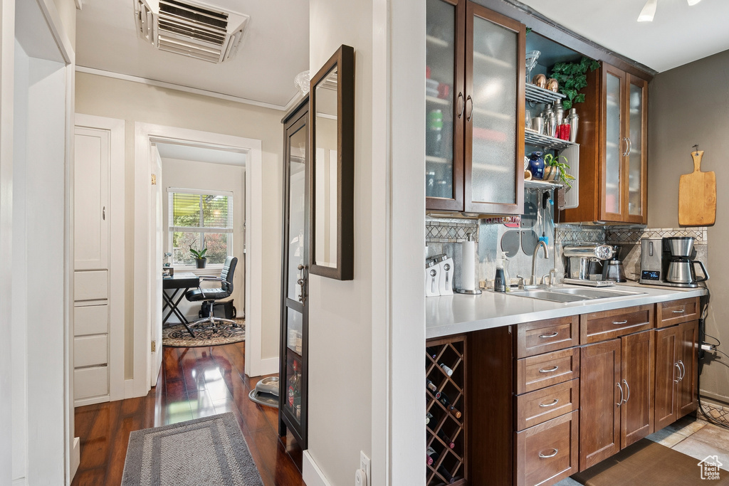 Bar featuring dark wood-type flooring and decorative backsplash