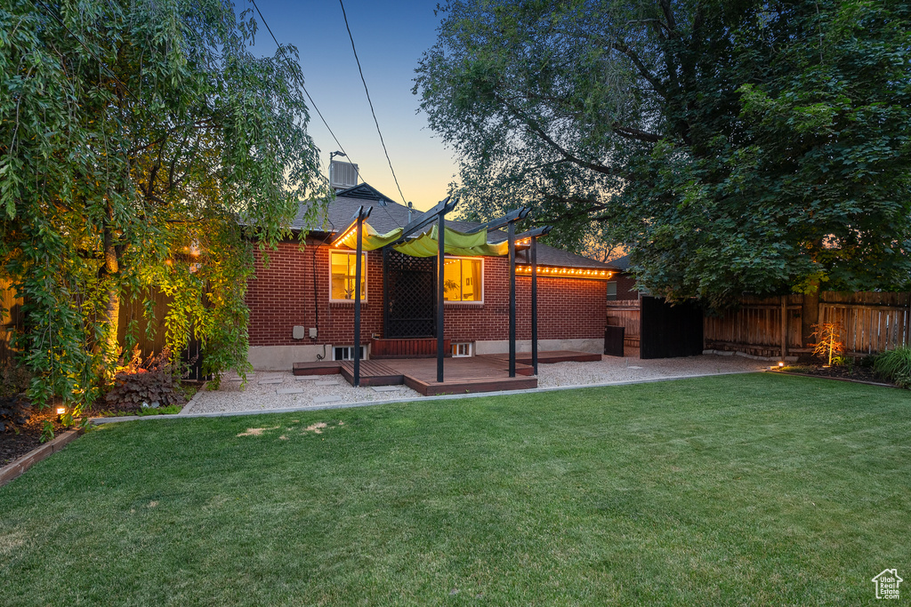 Rear view of property featuring a fenced backyard, a patio area, brick siding, and a deck