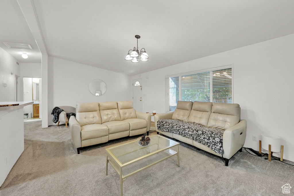 Carpeted living room with a chandelier