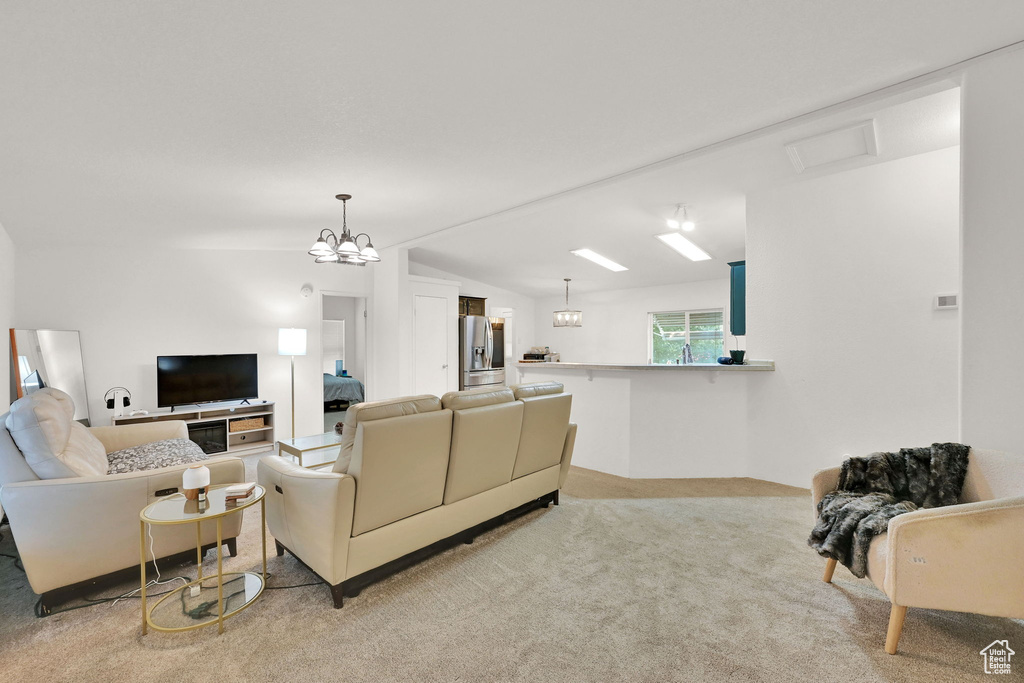 Living area featuring light colored carpet and a chandelier