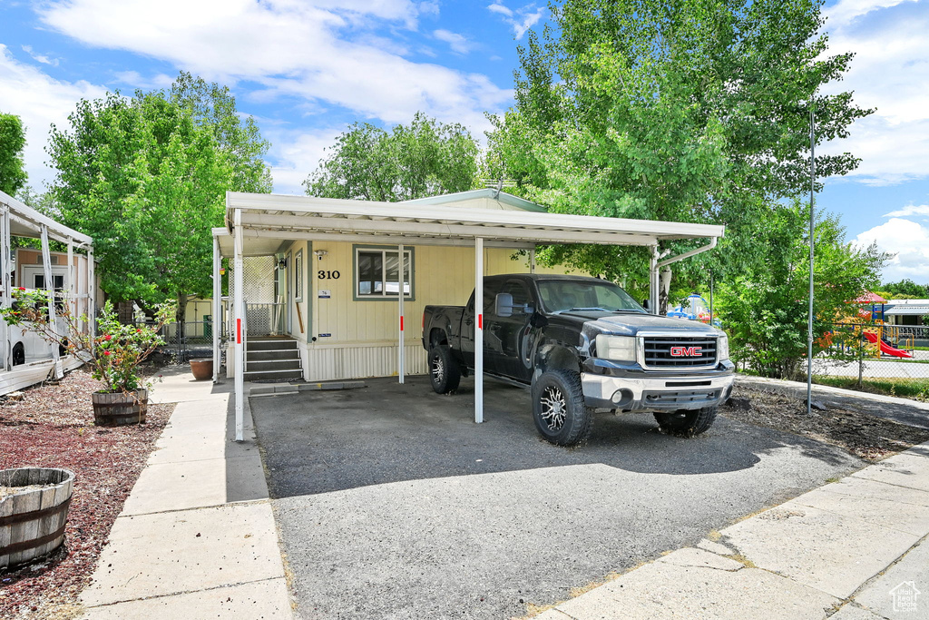 Manufactured / mobile home with asphalt driveway and a carport