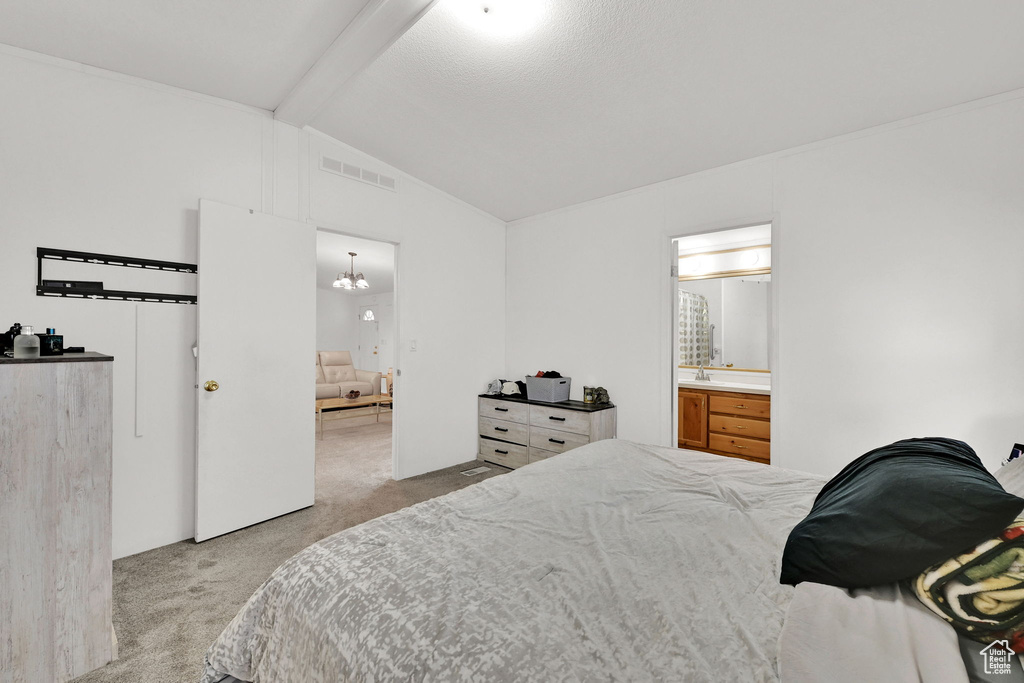 Bedroom with carpet flooring, ensuite bath, and a chandelier