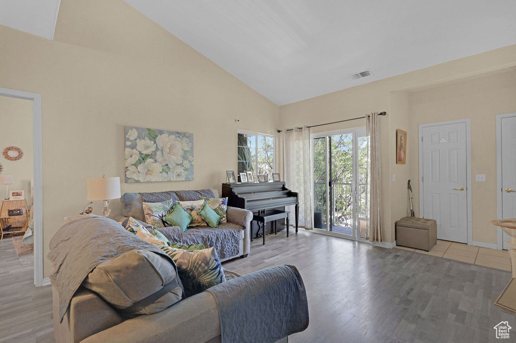 Living area with high vaulted ceiling and light wood-style flooring