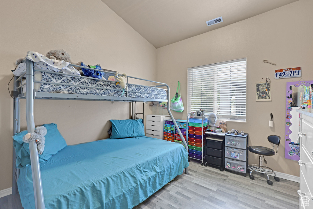 Bedroom with wood finished floors and vaulted ceiling