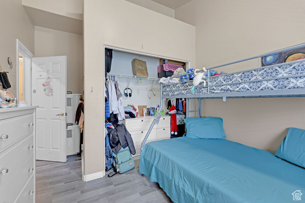 Bedroom with wood finished floors and a closet