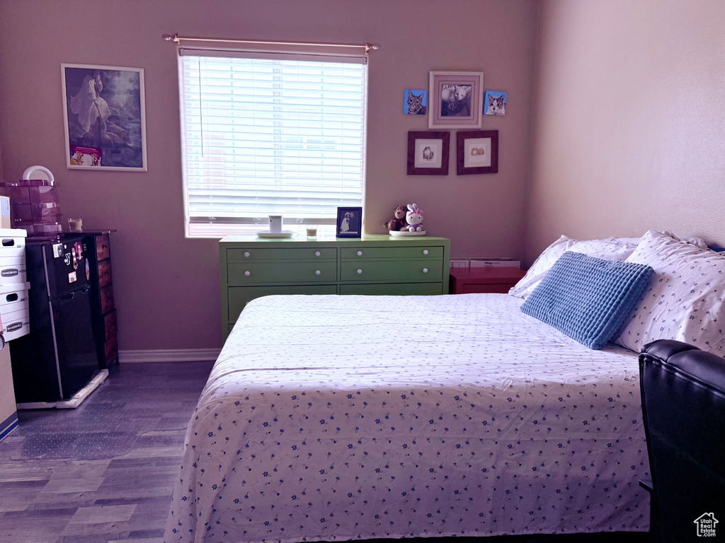 Bedroom featuring dark wood-style floors and baseboards