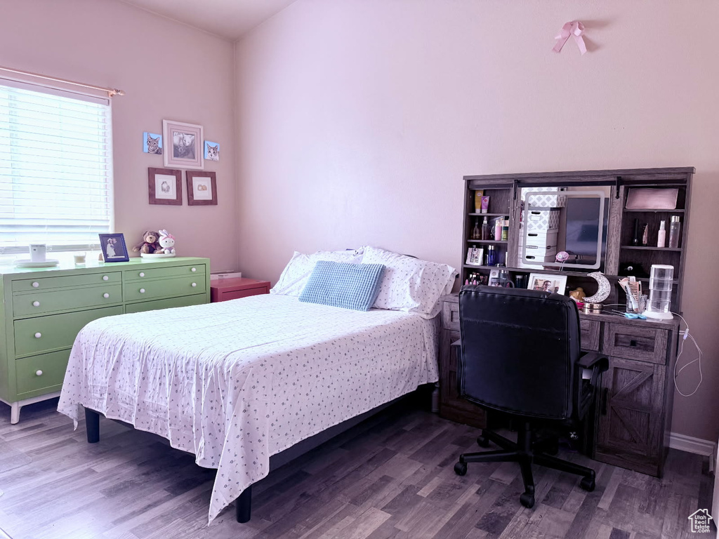 Bedroom featuring wood finished floors and an office area