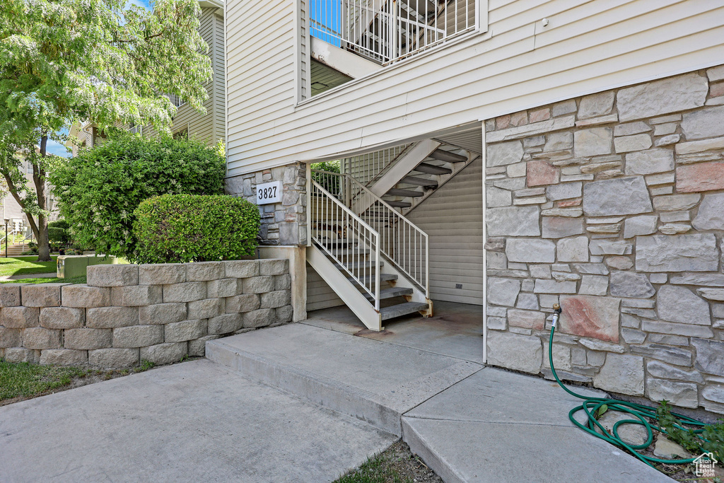Entrance to property with stone siding and a balcony