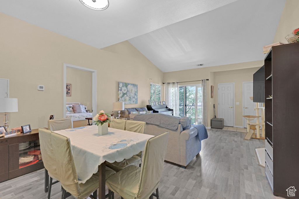 Dining space featuring light wood-style floors and high vaulted ceiling