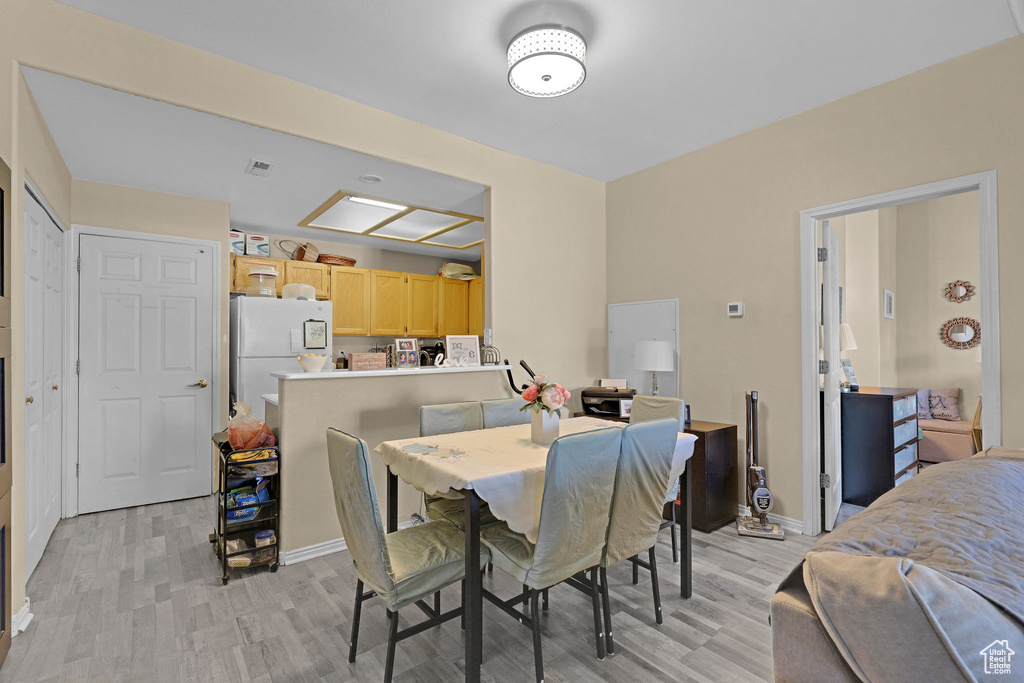 Dining area featuring light wood-style floors and baseboards
