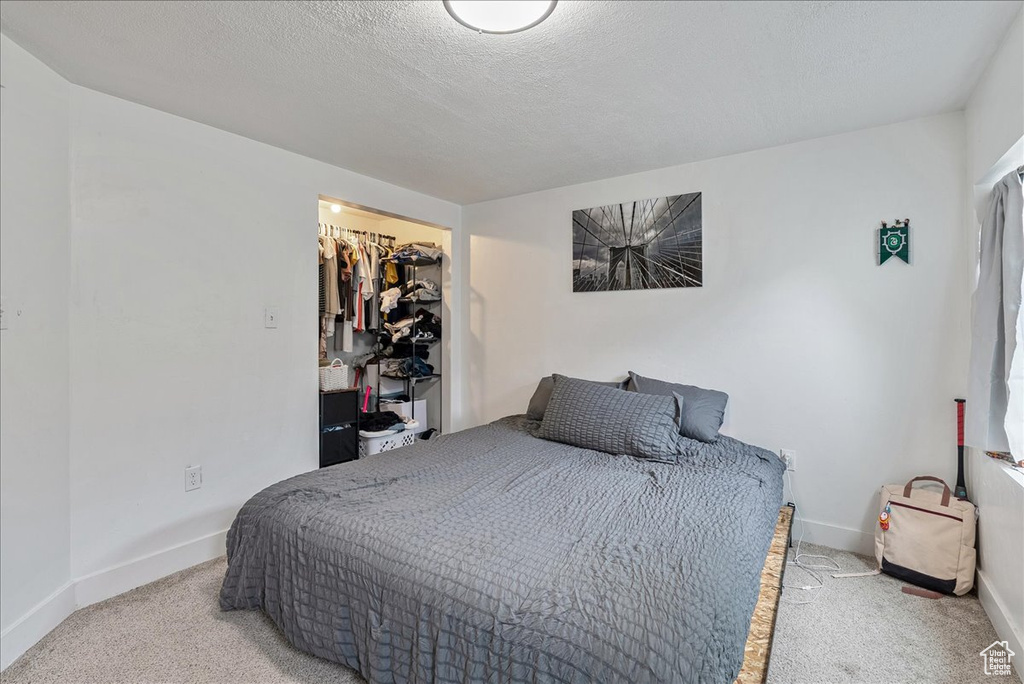 Bedroom featuring carpet floors and a textured ceiling