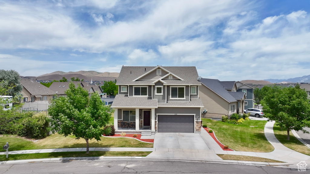 Craftsman house featuring driveway, a garage, roof with shingles, a front yard, and a residential view