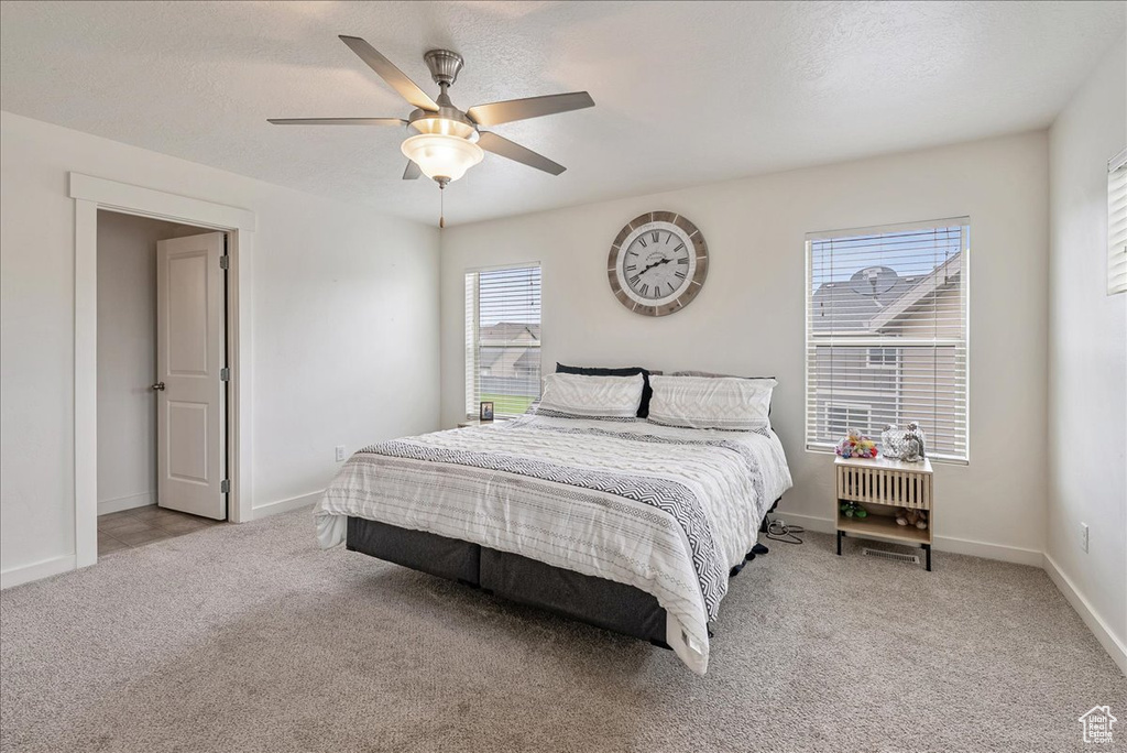 Carpeted bedroom featuring a ceiling fan and baseboards