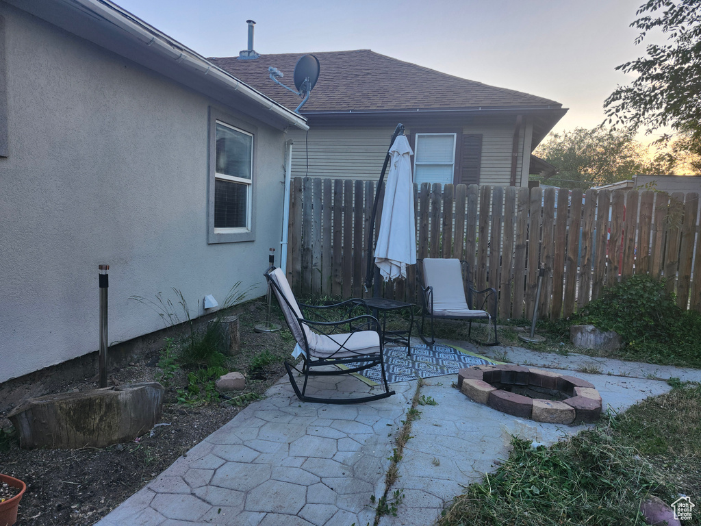 Patio terrace at dusk featuring a fire pit and a patio