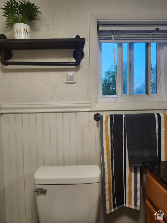 Bathroom featuring toilet and wainscoting