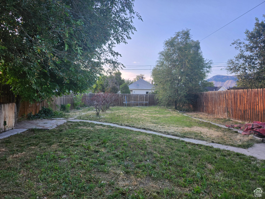 Fenced backyard featuring a mountain view