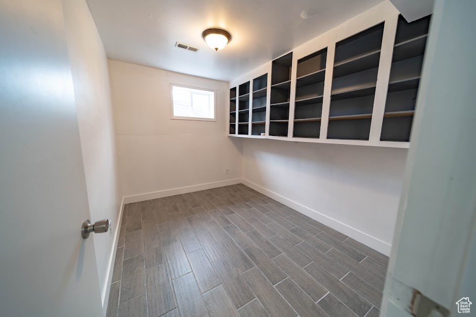 Empty room with baseboards and dark wood-style flooring