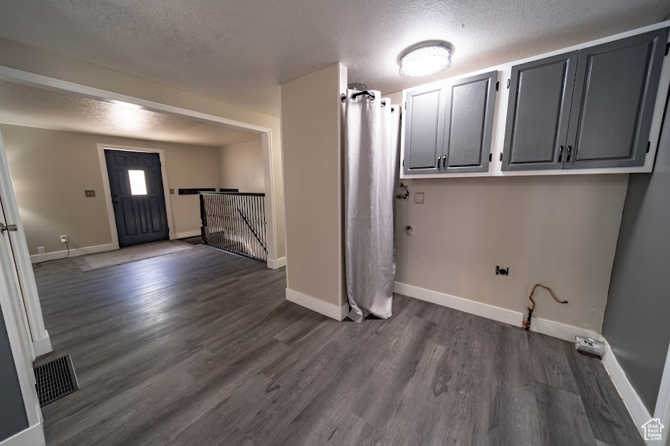 Foyer entrance featuring a textured ceiling and dark wood-style flooring