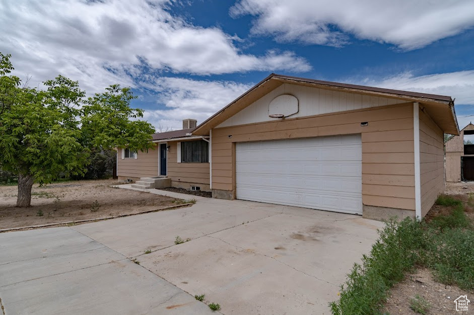 Ranch-style house featuring driveway and an attached garage