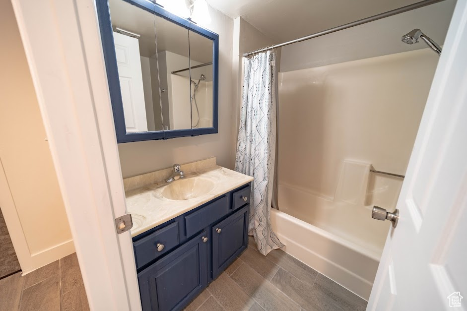 Bathroom featuring vanity and shower / bath combination with curtain