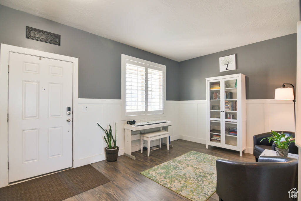 Foyer with wainscoting, wood finished floors, and a decorative wall