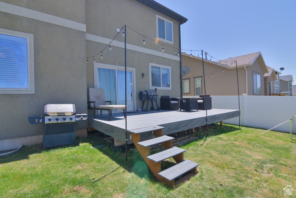 Back of house featuring stucco siding and a wooden deck