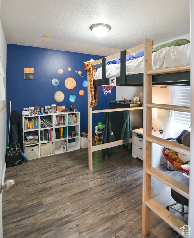 Bedroom featuring wood finished floors and a textured ceiling